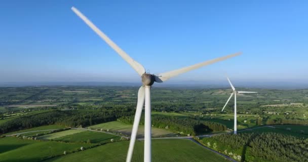 カメラは 評判の良い牧草地の背景に対して大規模な風車にズームします 風力タービンが付いている農場の航空写真 クリーンな再生可能エネルギーを生み出しています 代替エネルギーについて 5K映像について — ストック動画