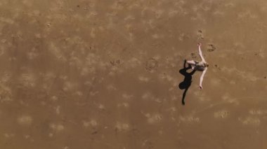Havadan. Little Girl 'ün sahilde denizin önünde takla attığı yavaş çekim. Yüksek kalite 4k görüntü