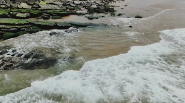 Havadan. Atlantik Okyanusu 'nun dalgaları kayalıklara çarpar. Atlantik Okyanusu 'nun kayalıklardaki dalgaları, Azenhas do Mar, Colares, Portekiz. Portekiz 2023 Slow Motion 4k