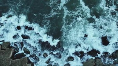 Ağır çekim 4k Aerial. Atlantik Okyanusu 'nun dalgaları kayalıklara çarpar. Atlantik Okyanusu 'nun kayalıklardaki dalgaları, Azenhas do Mar, Colares, Portekiz. Portekiz 2023 
