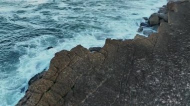 Havadan. Atlantik Okyanusu 'nun dalgaları kayalıklara çarpar. Atlantik Okyanusu 'nun kayalıklardaki dalgaları, Azenhas do Mar, Colares, Portekiz. Portekiz 2023 Slow Motion 4k