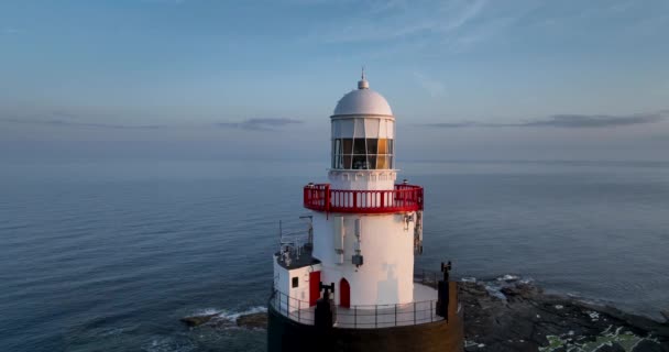 エアリアル 海を背景にした雄大な灯台 Hook Lighthouseは アイルランドのウェックスフォード郡フック半島の先端にホックヘッドに位置しています — ストック動画