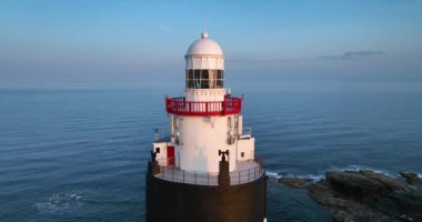 Wexford County, İrlanda 'daki Hook Deniz Feneri Yarımadası. Dünyanın en eski deniz feneri pitoresk pelerininde sakin ve büyülü bir günbatımı. 4k