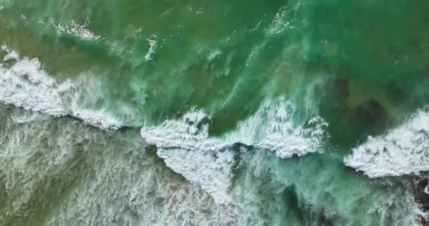 急峻な岩の崖の上で 回転する海の波 カメラは美しい家と海岸に向かって飛ぶ 高品質5K映像 — ストック動画