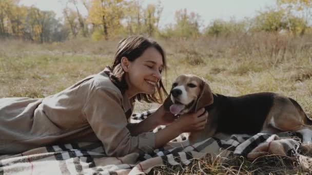 女孩躺在草地上 和她的狗玩耍 狗是人类最好的朋友 爱动物 慢动作 — 图库视频影像