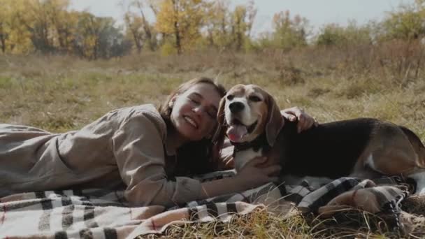 少女は芝生の芝生の上に横たわって犬と遊んでいる コンセプト 犬は人間の親友 動物の愛です スローモーション — ストック動画