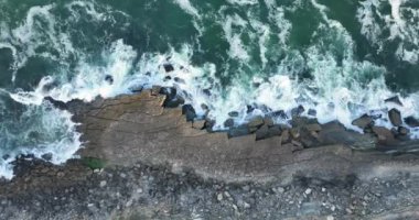 Portekiz, Avrupa 'daki Colares sahillerinde geniş dalgalar dalgaları vuruyor. 2023. Fırtınalı havada Atlantik Okyanusu. Köpük dalgaları kayalara çarpıyor. 