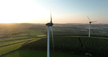 Havadan. Rüzgar türbinleri gün batımında duruyor. Rüzgâr türbinli bir çiftliğin havadan çekilmiş fotoğrafı. Temiz yenilenebilir enerji üretiyor. Alternatif enerji. Kilkenny Ireland. Yüksek kalite 4k görüntü