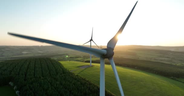 エアリアル 風力タービンは日没時に立っています 風力タービンが付いている農場の航空写真 クリーンな再生可能エネルギーを生み出しています 代替エネルギーについて キルケニー アイルランド 高品質の4K映像 — ストック動画