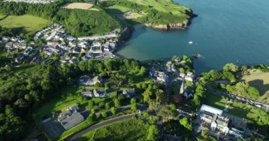 Havadan. Güzel beyaz rıhtım evleri olan sinematik kıyı şeridi. Gün batımı. Dunmore East County Waterford, İrlanda 'da. Yüksek kalite 4k görüntü