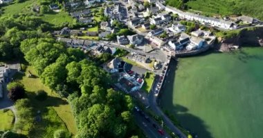 Havadan. Güzel beyaz rıhtım evleri olan sinematik kıyı şeridi. Gün batımı. Dunmore East County Waterford, İrlanda 'da. Yüksek kalite 4k görüntü