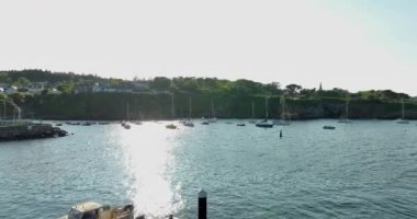 Havadan. Sahilde kayalık kıyı şeridinde güzel yatları olan inanılmaz bir sahil şeridi. Gün batımı. Dunmore East County Waterford, İrlanda 'da. Yüksek kalite 4k görüntü
