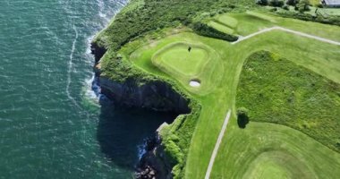 Havadan. Dairesel. Okyanusun yakınındaki kayalık kayalıklarda bir golf sahası. Dunmore East County Waterford, İrlanda 'da. Yüksek kalite 4k görüntü