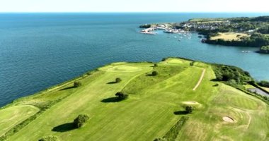 Havadan. Dairesel. Okyanusun yakınındaki kayalık kayalıklarda bir golf sahası. Dunmore East County Waterford, İrlanda 'da. Yüksek kalite 4k görüntü