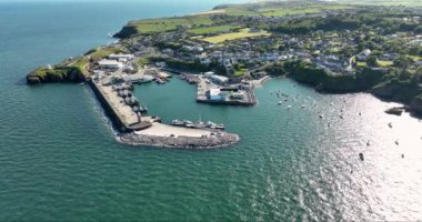 Havadan. Güzel bir deniz feneri ve balıkçı tekneleri için iskelesi olan inanılmaz bir sahil şeridi. Gün batımı. Dunmore East County Waterford, İrlanda 'da. Yüksek kalite 4k görüntü