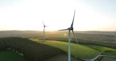 Havadan. Rüzgar türbinleri gün batımında duruyor. Rüzgâr türbinli bir çiftliğin havadan çekilmiş fotoğrafı. Temiz yenilenebilir enerji üretiyor. Alternatif enerji. Kilkenny Ireland. Yüksek kalite 4k görüntü
