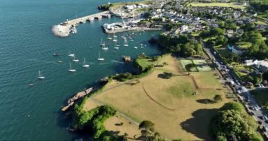 Havadan. Kayalık kıyı şeridinde balıkçı tekneleri olan çok güzel deniz feneri olan inanılmaz bir sahil şeridi. Gün batımı. Dunmore East County Waterford, İrlanda 'da. Yüksek kalite 4k görüntü