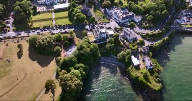 Havadan. Güzel beyaz rıhtım evleri olan sinematik kıyı şeridi. Gün batımı. Dunmore East County Waterford, İrlanda 'da. Yüksek kalite 4k görüntü