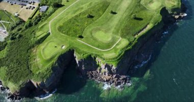 Havadan. Okyanusun yakınındaki kayalık kayalıklarda bir golf sahası. Dunmore East County Waterford, İrlanda 'da. Waterford Limanı 'nın batı yakasında. Yüksek kalite 4k görüntü