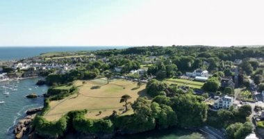 Havadan. Güzel beyaz rıhtım evleri olan sinematik kıyı şeridi. Gün batımı. Dunmore East County Waterford, İrlanda 'da. Yüksek kalite 4k görüntü