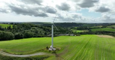 Havadan. Dairesel. Bıçaklı yel değirmeni, İrlanda 'nın yeşil alanlarına karşı Alternatif enerji vadisi. İrlanda. Yüksek kalite 4k