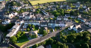 Havadan. Güzel beyaz rıhtım evleri ve balıkçı tekneleri olan sinematik sahil şeridi. Gün batımı. Dunmore East County Waterford, İrlanda 'da. Yüksek kalite 4k görüntü