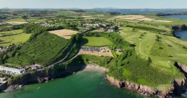 Havadan. Okyanusun yakınındaki kayalık kayalıklarda bir golf sahası. Dunmore East County Waterford, İrlanda 'da. Yüksek kalite 4k görüntü