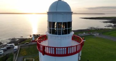 Wexford County, İrlanda 'daki Hook Deniz Feneri Yarımadası. Dünyanın en eski deniz feneri pitoresk pelerininde sakin ve büyülü bir günbatımı. 4k