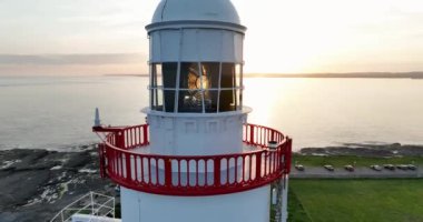 Wexford County, İrlanda 'daki Hook Deniz Feneri Yarımadası. Dünyanın en eski deniz feneri pitoresk pelerininde sakin ve büyülü bir günbatımı. 4k