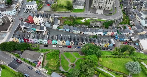 エアリアル 急な斜面に多彩な家が建っている アイルランドのカラフルな家とセント大聖堂 高品質の4K映像 — ストック動画