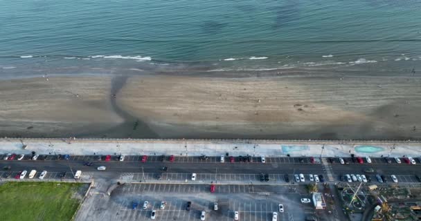 エアリアル 遊園地と海岸沿いの大きな駐車場を見ることができます 職業について 海岸から 高品質の4K映像 — ストック動画