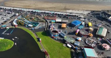 Havadan. Tramore 'daki Atlantik Okyanusu sahilinin arka planına karşı bir lunapark. Aile tatili. Meslek. Deniz kenarında. Yüksek kalite 4k görüntü