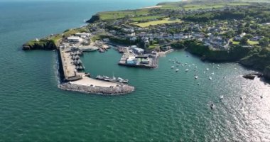 Havadan. Güzel bir deniz feneri ve balıkçı tekneleri için iskelesi olan inanılmaz bir sahil şeridi. Gün batımı. Dunmore East County Waterford, İrlanda 'da. Yüksek kalite 4k görüntü