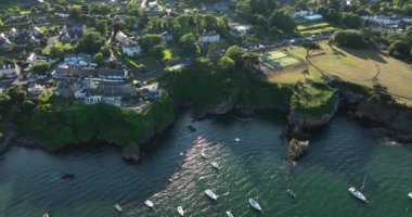 Havadan. Güzel evleri ve kayalık kıyı şeridinde balıkçı tekneleri olan inanılmaz bir sahil şeridi. Gün batımı. Dunmore East County Waterford, İrlanda 'da. Yüksek kalite 4k görüntü