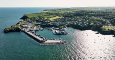 Havadan. Güzel bir deniz feneri ve balıkçı tekneleri için iskelesi olan inanılmaz bir sahil şeridi. Gün batımı. Dunmore East County Waterford, İrlanda 'da. Yüksek kalite 4k görüntü