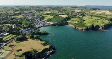 Havadan. Güzel evleri ve kayalık kıyılara yakın balıkçı tekneleri olan resimli bir sahil. Gün batımı. East Dunmore, Waterford County, İrlanda. 4K 'da yüksek kaliteli görüntüler.