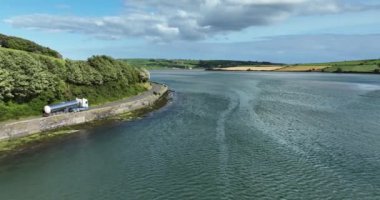 Havadan. Yazın göl boyunca yolda giden gümüş bir kamyon. Bir kamyon gümüş bir bira tankeri taşıyor. İrlanda. Yüksek kalite 4k görüntü