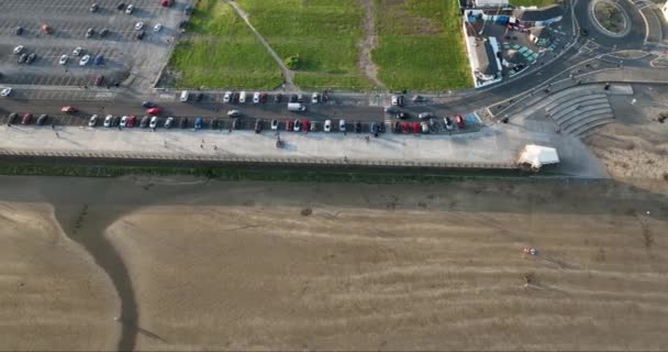 エアリアル 垂直に 海は波でビーチを洗っている 夕暮れにビーチを歩いている人たち 沿岸に駐車した車両 トロモア ウォーターフォード アイルランド — ストック動画