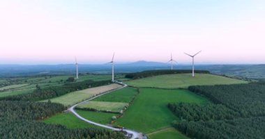Hava 4k. Kocaman yel değirmenleri yemyeşil çayır zeminine karşı. Temiz yenilenebilir enerji üretiyor. Alternatif enerji. 4k