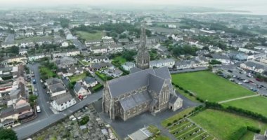 Havadan. Kutsal Haç Katolik Kilisesi 'nin üzerinde uçarken tüm kıyı kasabası Tramore, İrlanda' ya bakıyor. Sisli bir gün. 4k biçiminde yüksek kaliteli görüntüler