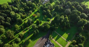 Havadan. Yeşil parkı ve arka planında tenis kortu olan lüks bir ev. Blarney Evi. Gün doğumu. Mantar İrlanda Yüksek kalite 4K görüntü