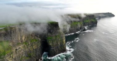 Anne kıyı kayalıklarının alçak bulutlarla örtülü hava görüntüleri. Moher, Clare, İrlanda uçurumları. Yüksek kalite 4k görüntü