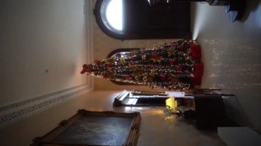 Dikey. Muhteşem bir kır evinde lüks bir Noel ağacı. Yılbaşı ağacı, eski bir kır evinin lüks içinde. İrlanda. Yavaş çekim 