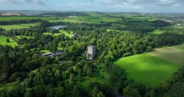 Havadan. Eski bir İrlanda şatosunun üzerinde uçuyor. Yeşil bahçelerin arka planında Blarney Kalesi. Mantar, İrlanda. Yüksek kalite 4k görüntü