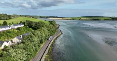 Havadan. Yazın göl boyunca yolda giden gümüş bir kamyon. Bir kamyon gümüş bir bira tankeri taşıyor. İrlanda. Yüksek kalite 4k görüntü