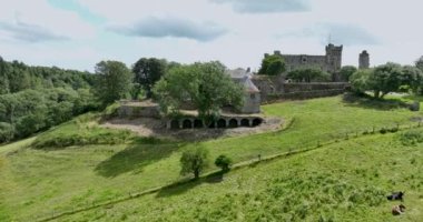 Havadan. Fotoğraf makinesi, antik bir kaleden İrlanda 'nın pitoresk kırsal kesimine doğru uçuyor. Küçük bir çiftlik. Kilbrittain Ormanı. 4k biçiminde yüksek kaliteli görüntüler