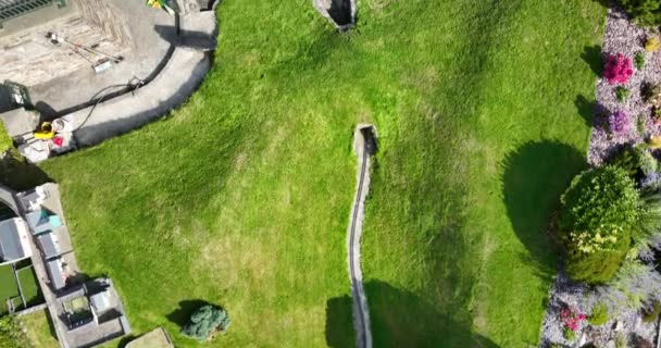 エアリアル サーキュラー ミニチュアタウンと作業ミニ鉄道線を持つ壮大な公園 アイルランドの町の小さな建物 ウェストコーク モデル鉄道ビレッジ 高品質の4K映像 — ストック動画