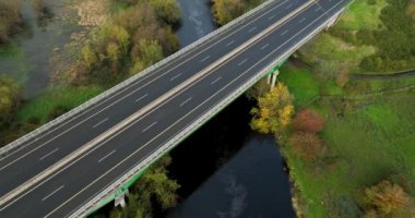 Havadan. Üç araba Nore Nehri üzerindeki pitoresk bir köprüden geçiyor. İrlanda. Yüksek kalite 4k görüntü