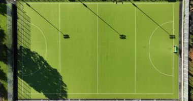 Hava görüntüsü. Yeşil çimen aktif spor hokeyi ve yukarıdan aşağıya doğru futbol sahaları. Rekabet mahkemesi sahada aktif insanlar ve çocuklar var. Yüksek kalite 4k görüntü