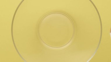 Cipslerin sarı bir zemine doğru açık bir tabağa düşüşünün yavaş çekim görüntüleri. Yavaş çekim. Yüksek kaliteli FullHD görüntüler